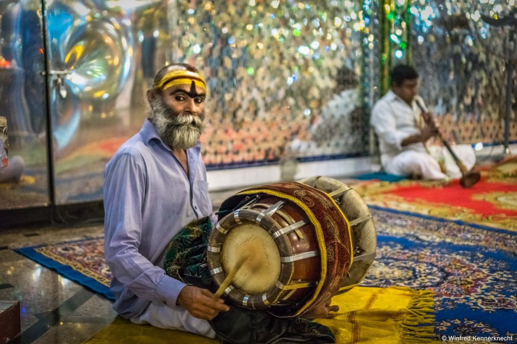 Religious man drumming at Arulmigu Sri Rajakaliamman Glass Temple in Johor Bahru, Malaysia.